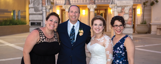 Four smiling people pose in a room